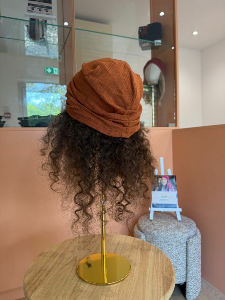 Couronne aux cheveux bouclés portée sous un turban, vue de dos, au showroom