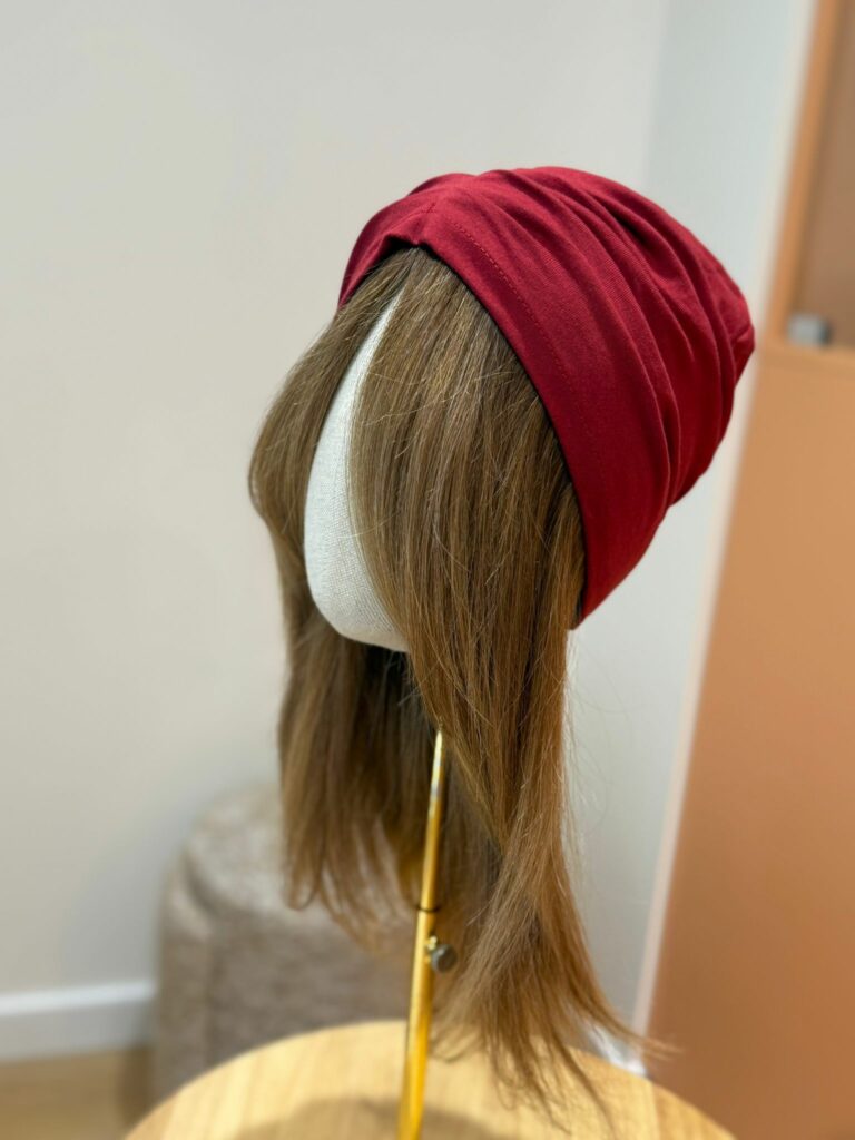 La même couronne portée sous un turban bordeaux : seuls les cheveux dépassent